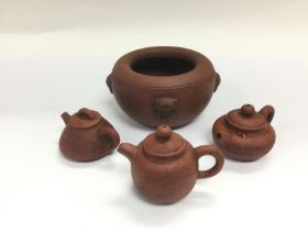 Four terracotta items comprising a pot and three m