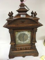 A late 19th century walnut mantel clock with a silvered chapter ring with striking movement with key