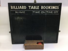 A wooden billiards score board and three billiard