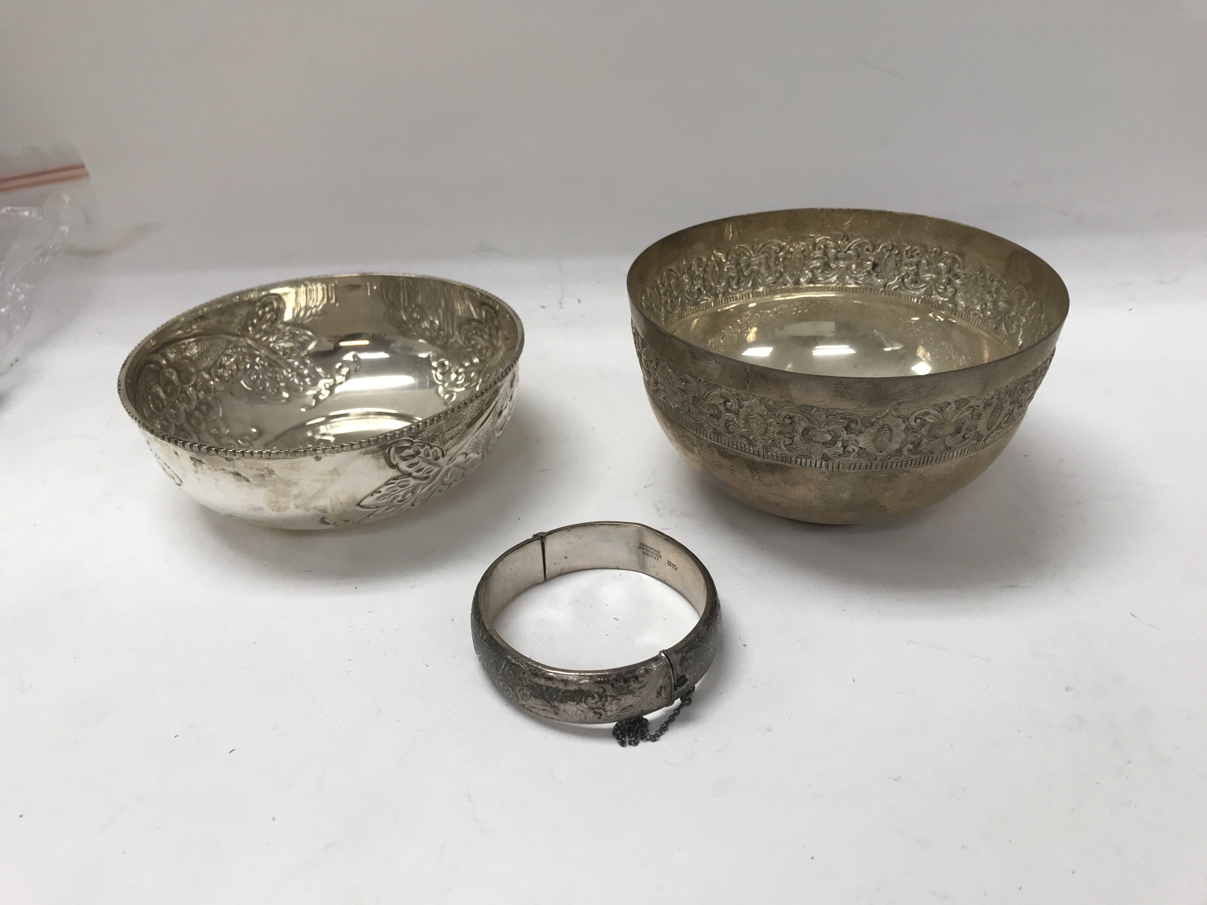 Two silver bowls and one silver bangle.