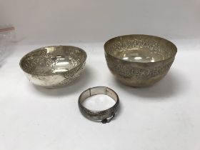 Two silver bowls and one silver bangle.