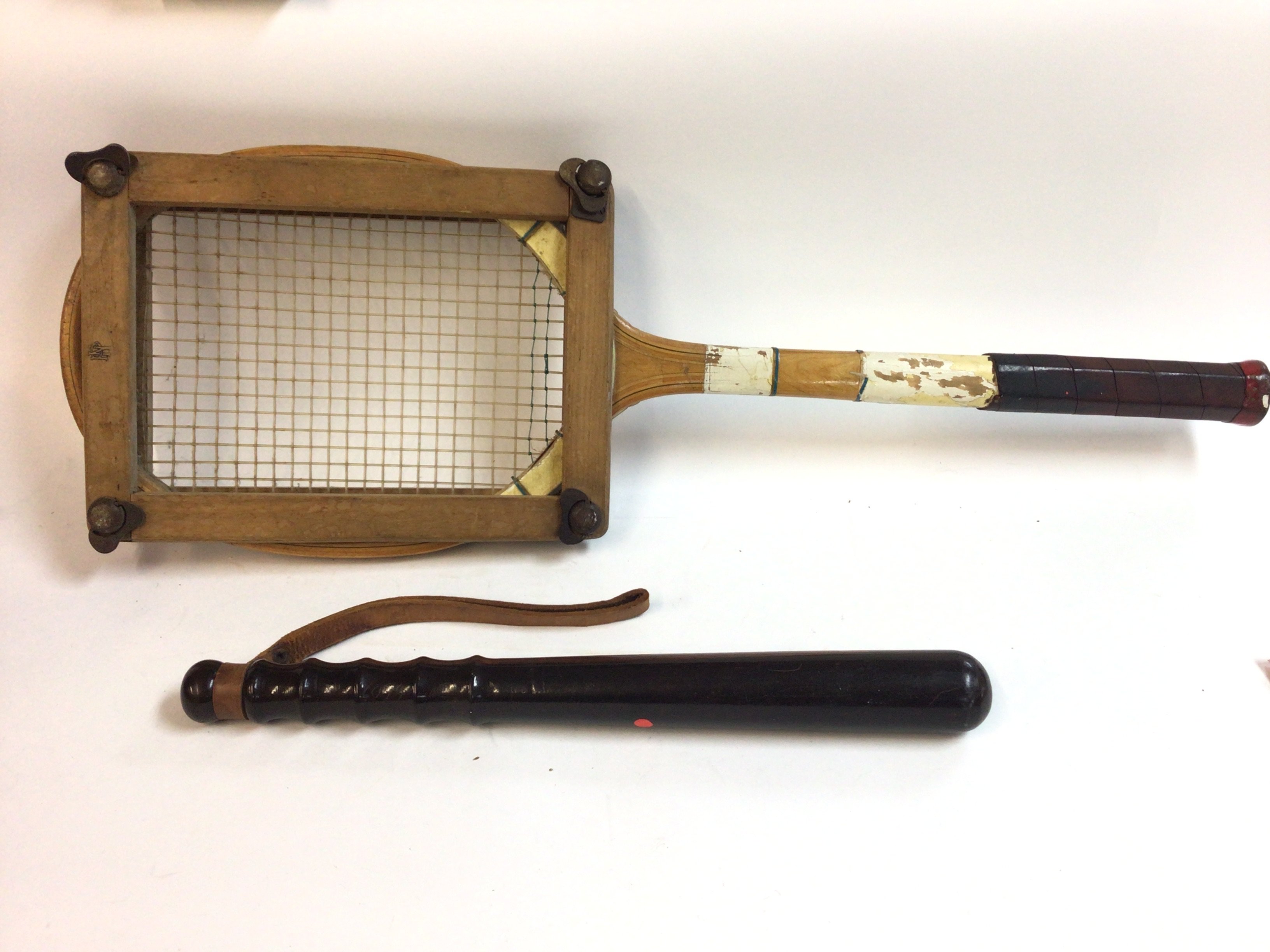 An old cricket bat along with a vintage tennis rac