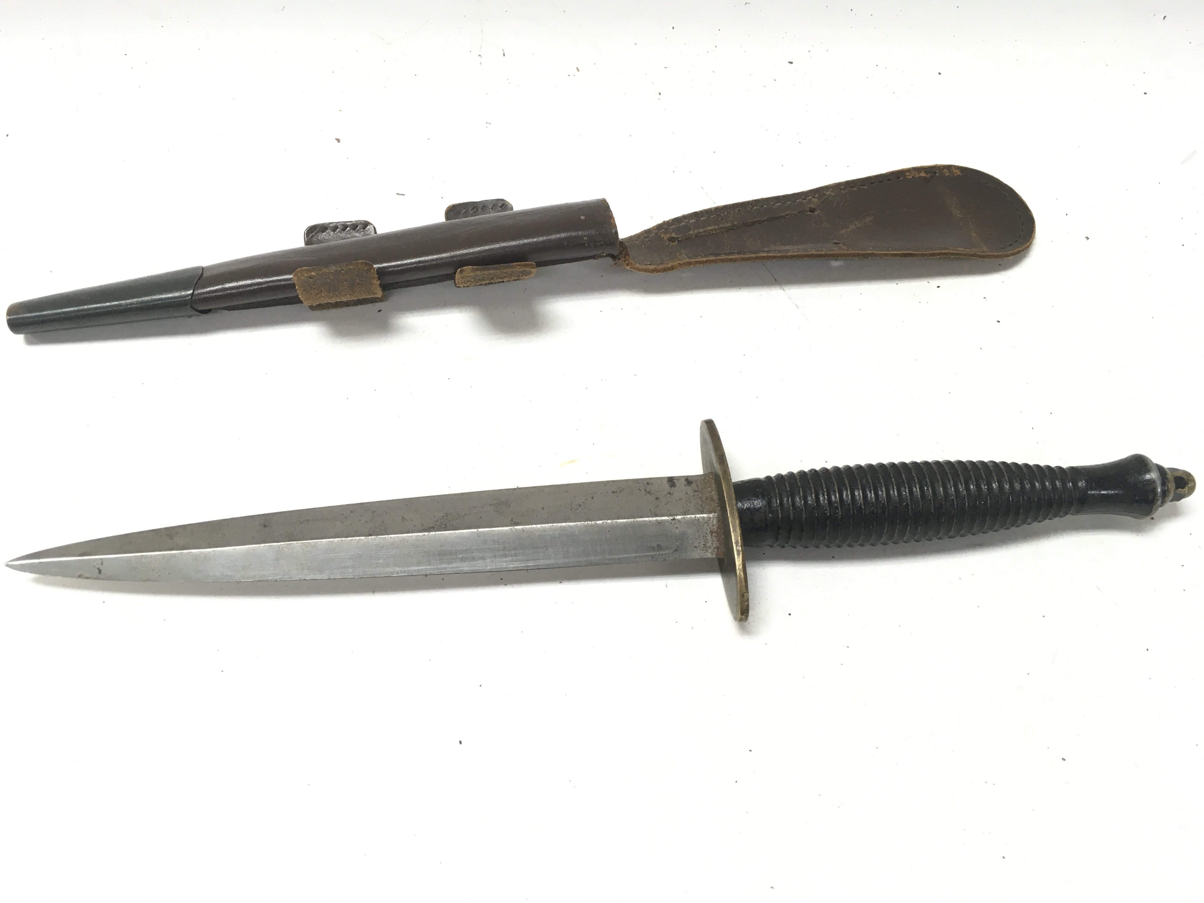 A Fairbairn Sykes fighting knife with leather scab