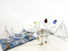 A Collection of boxed Swarovski ornaments including boats, tulips, a plane etc. Some damage, this