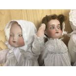 Three German bisque head dolls together with pram