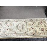 A hand tied wool hall runner rug. 182cm by 64 cm a