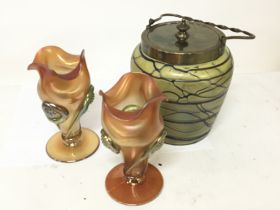A Loetz style glass biscuit barrel and a pair of vases no obvious damage. (3)