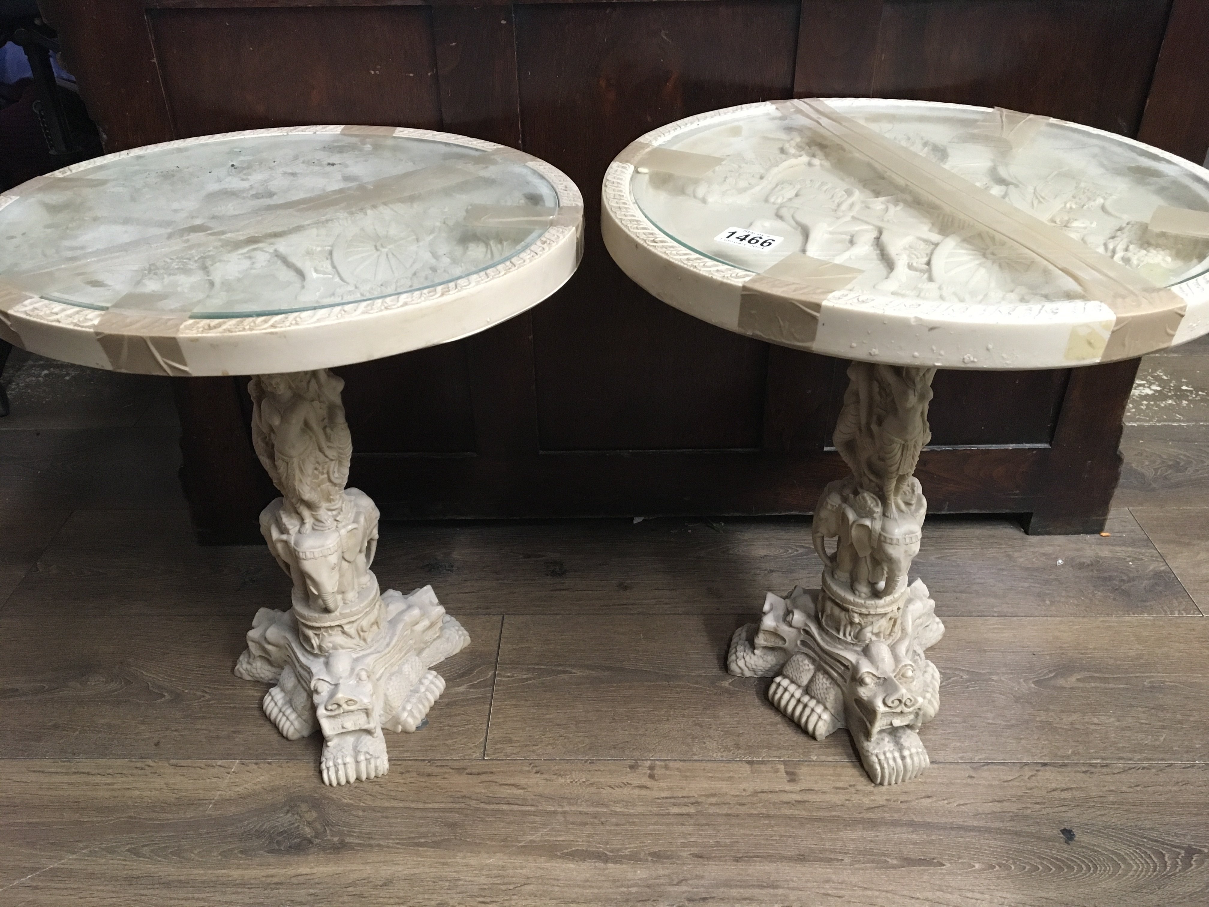 A pair of resin occasional tables with raised deco