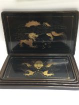 Five graduated Oriental lacquered trays, largest a