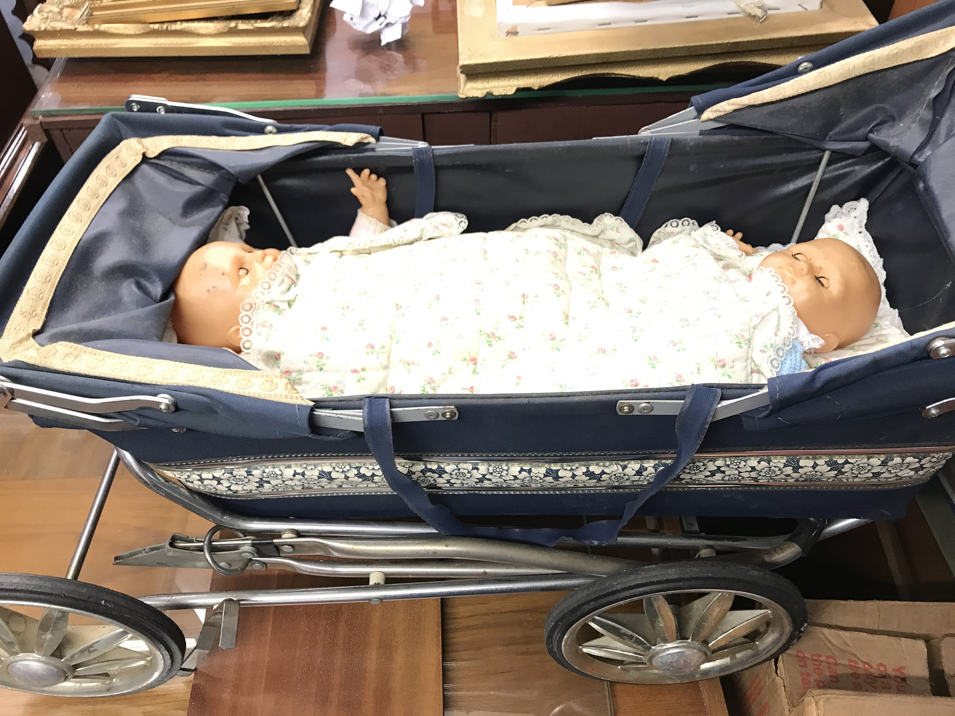 A vintage dolls pushchair and two dolls along with