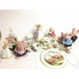 A collection of ceramics including Wade piggy banks, Enesco Peter Rabbit containers etc. This lot