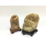 Two carved soapstone ornaments raised on carved ha