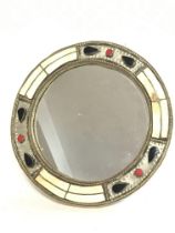 A brass mirror inlaid with various stone decoratio