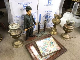 A collection of items including oil lamps with shades, twist candlesticks and a Charlie Chaplin