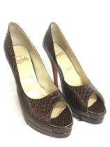 A pair of high heels by Loboutine In snake leather