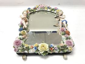 A Dresden or Meissen mirror with cherubs and flowers. 46x31cm approx Postage D