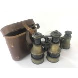 A cased pair of Hughes brass body field binoculars