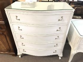 A white wood serpentine front chest of five drawer