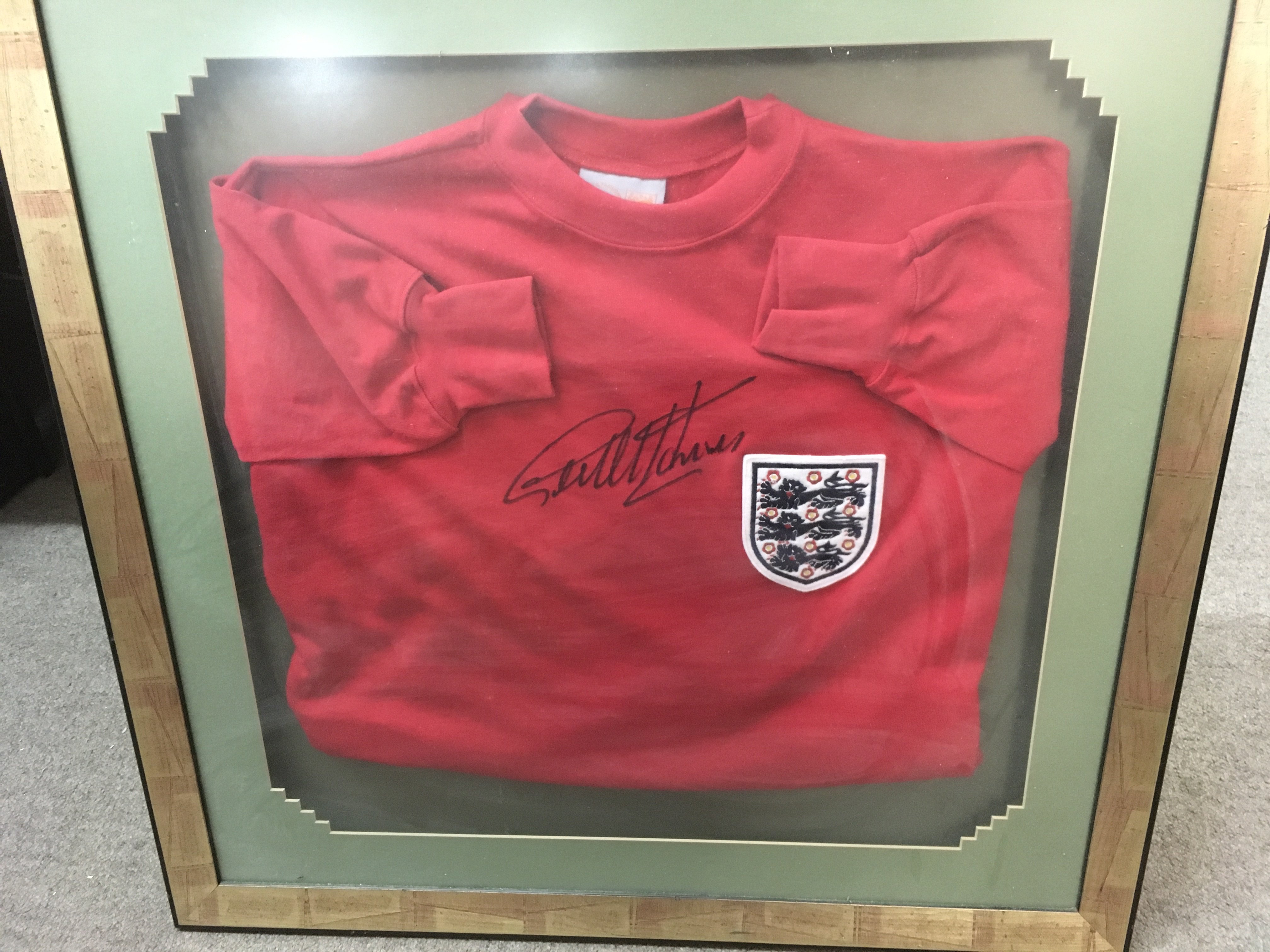 A framed England football jumper signed by Geoff Hurst, this lot cannot be posted. Frame