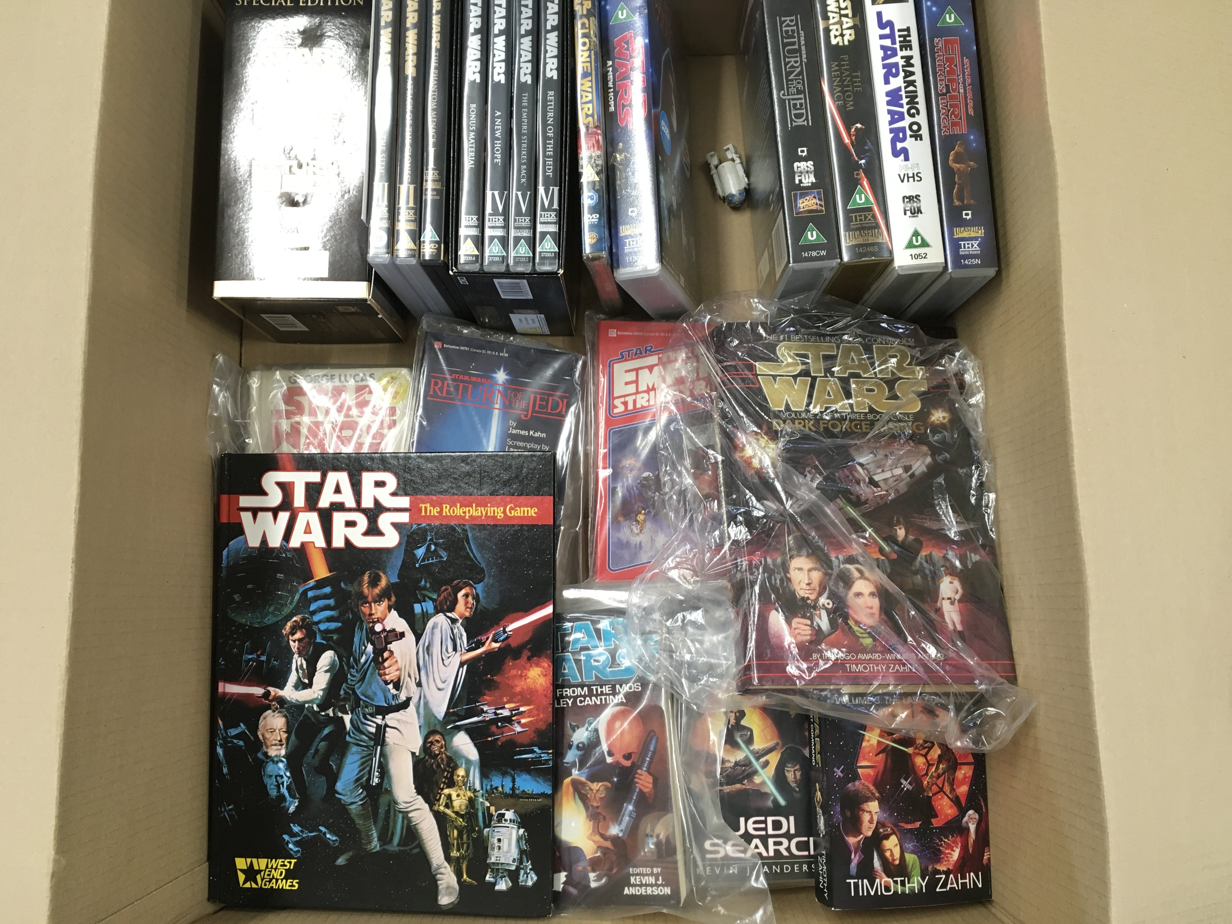 A Box Containing Star Wars Dvds. Vhs and Books. No