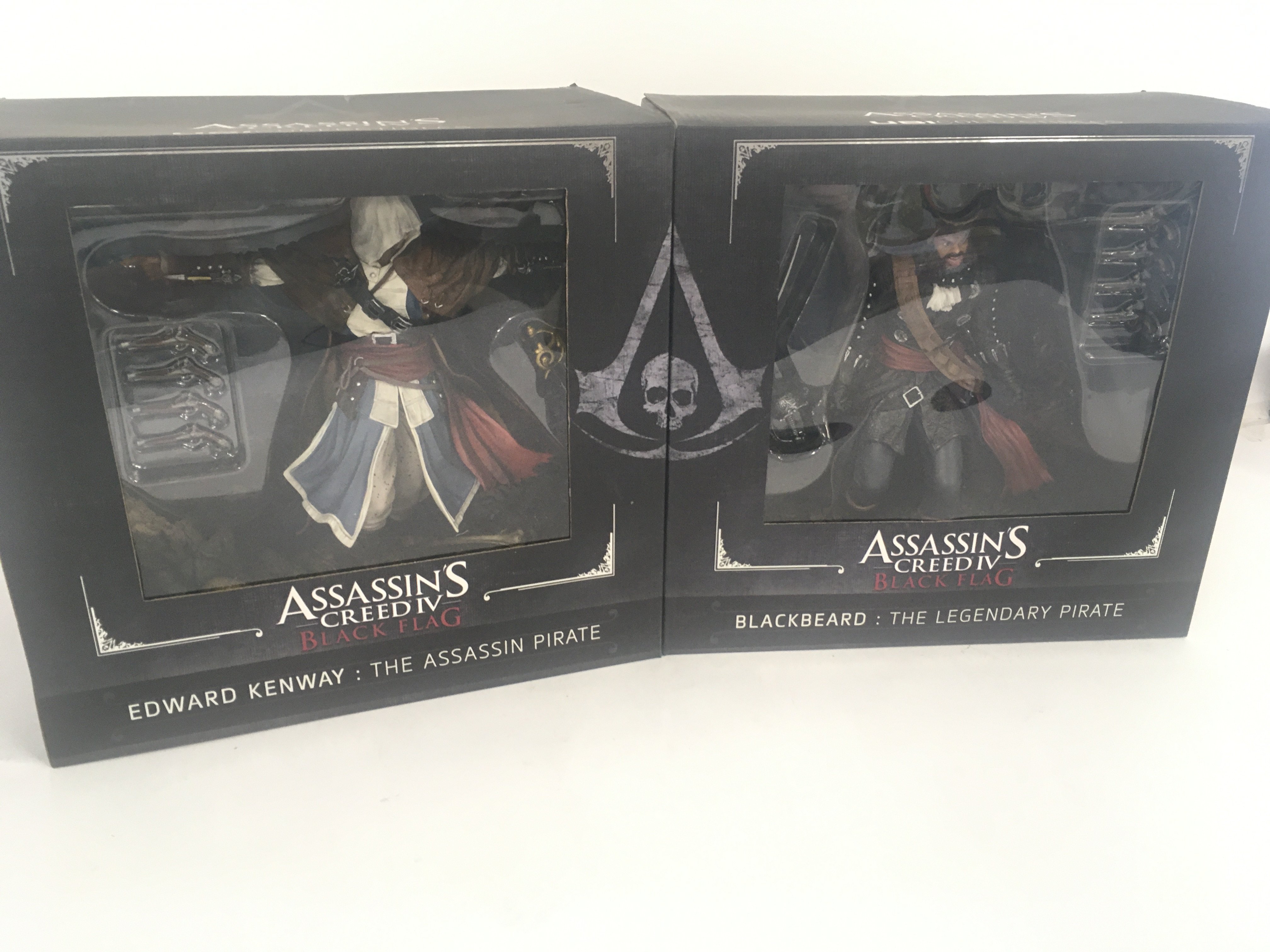 A par of boxed ASSASSINS CREED IV action figures.