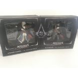 A par of boxed ASSASSINS CREED IV action figures.