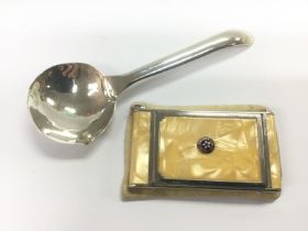 A silver spoon and a compact inset with a US air force emblem to the front (2). Shipping category A.