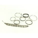 A collection of silver bangles and a gate bracelet