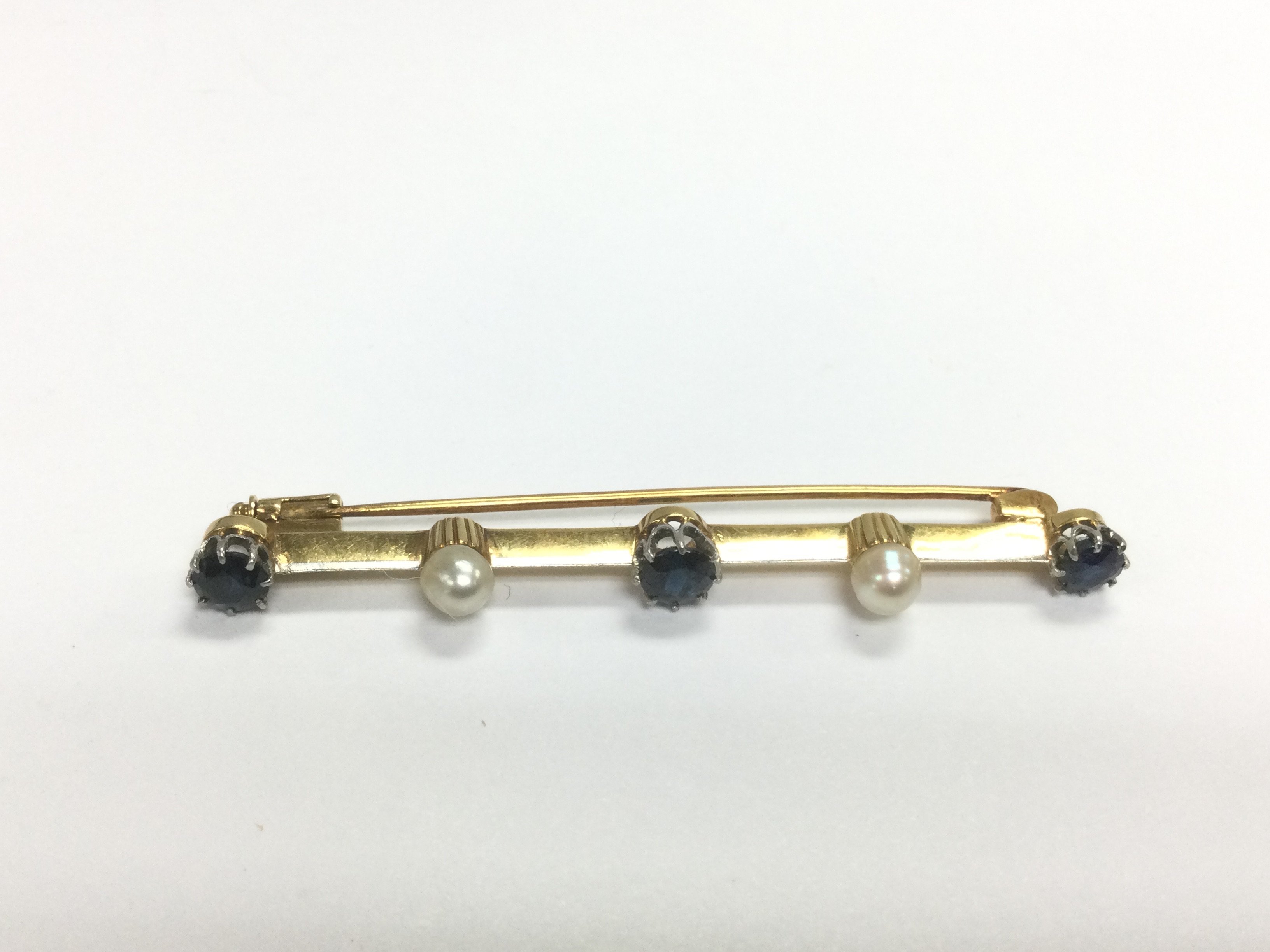 A gold bar brooch set with sapphires and pearls, a