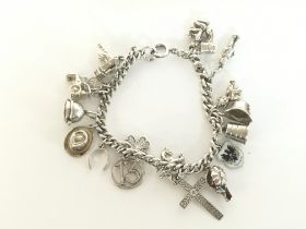 A silver charm bracelet including some enamel char