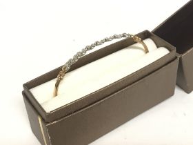 A 9ct gold bangle set with small moissanite shards