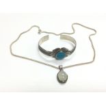 A moonstone pendant on a silver chain and a silver