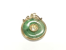 A Chinese jade pendant inset in an unmarked gold m