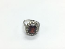 An 18ct gold ring set with a central garnet surrou