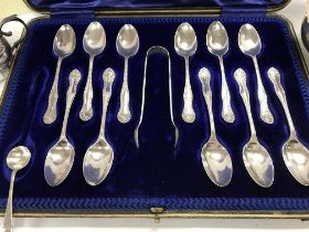 A case containing 11 silver tea spoons and a pair