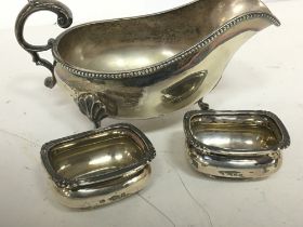 A silver plated gravy boat and a pair of silver sa