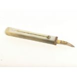 A gold mounted mother of Pearl toothpick. Postage