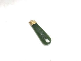 A gold unmarked jade pendant.