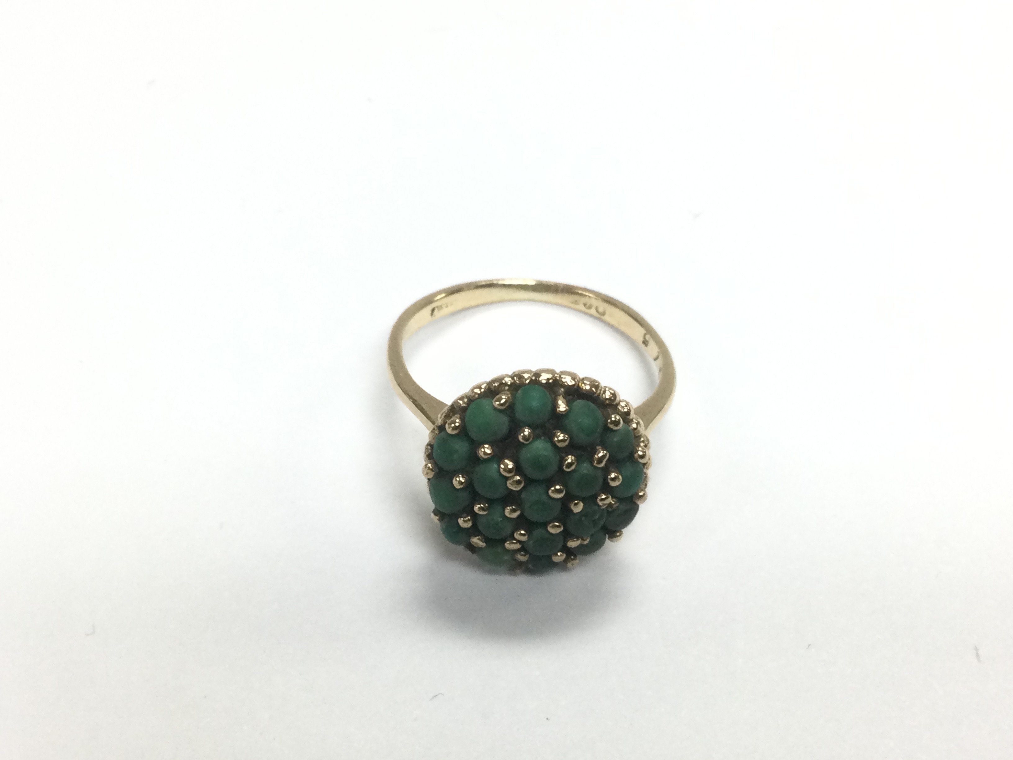 A gold ring set with green stones, approx 3g and a