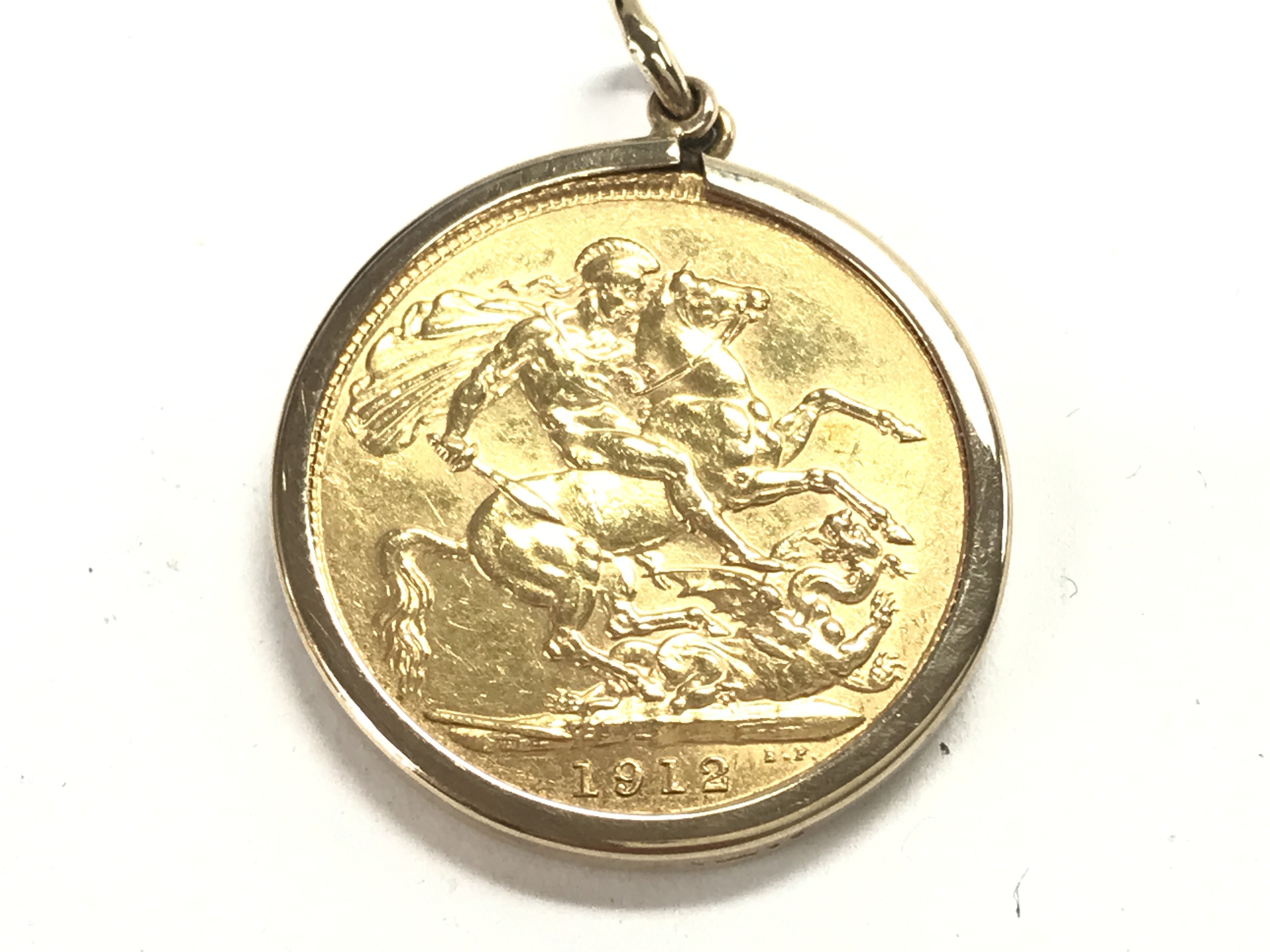 A 1912 full sovereign in mount. Postage A