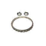 A modern silver and stone set bangle and earrings.