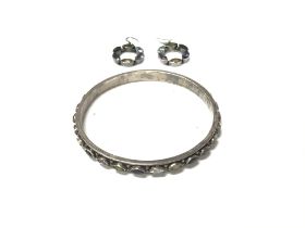 A modern silver and stone set bangle and earrings.