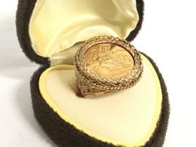 A 9 carat gold ring set with a half sovereign H/I.