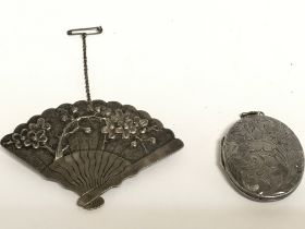 A Chinese silver fan brooch and a silver locket. P