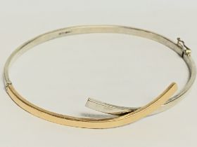 A 9 carat gold two tone bangle. Postage category A