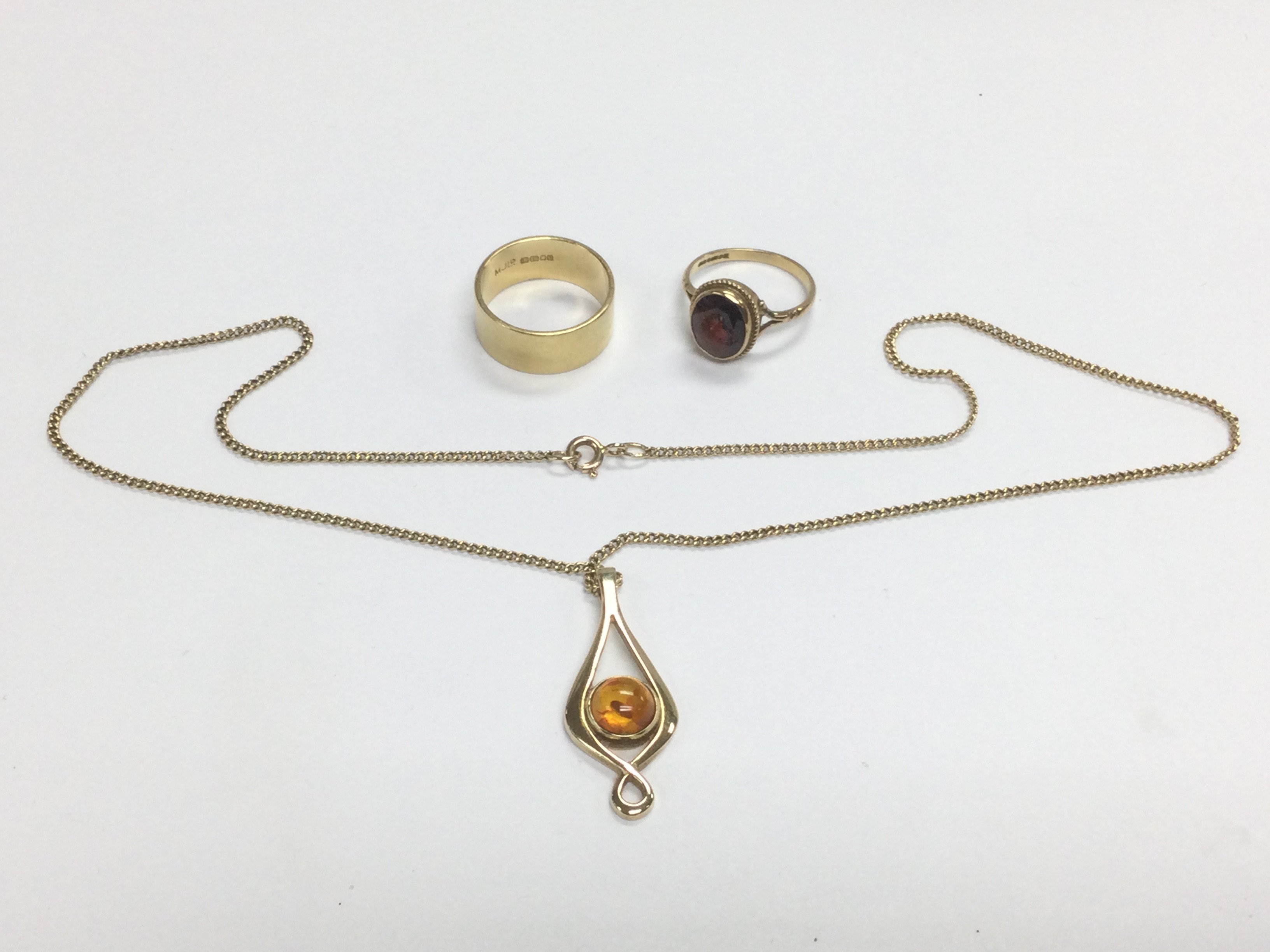 A gold and amber pendant, an 18ct gold wedding ban