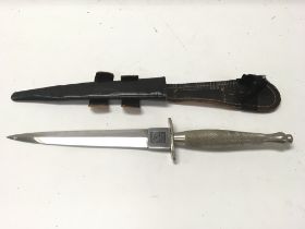 A Fairbairn Sykes fighting knife with leather scab