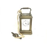 A small brass carriage clock with key, seen workin