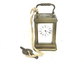 A small brass carriage clock with key, seen workin