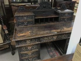 A Late Victorian oak carved desk with leather top,